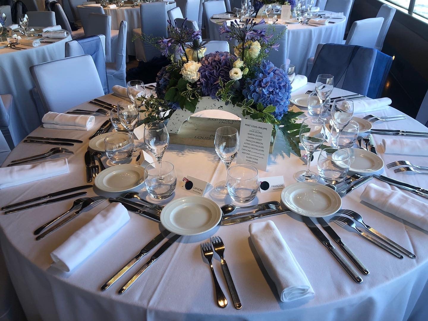 Table ronde dressée avec un centre de table fleuri
